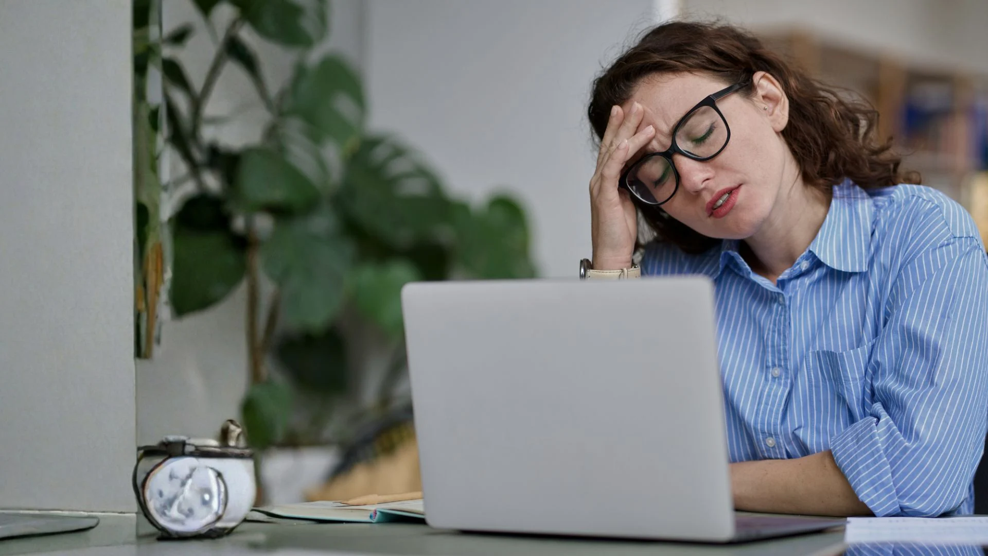 Tired packaging team member working at a laptop